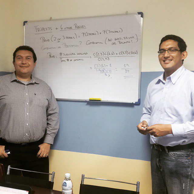 Two instructors standing beside a whiteboard full of probability calculations